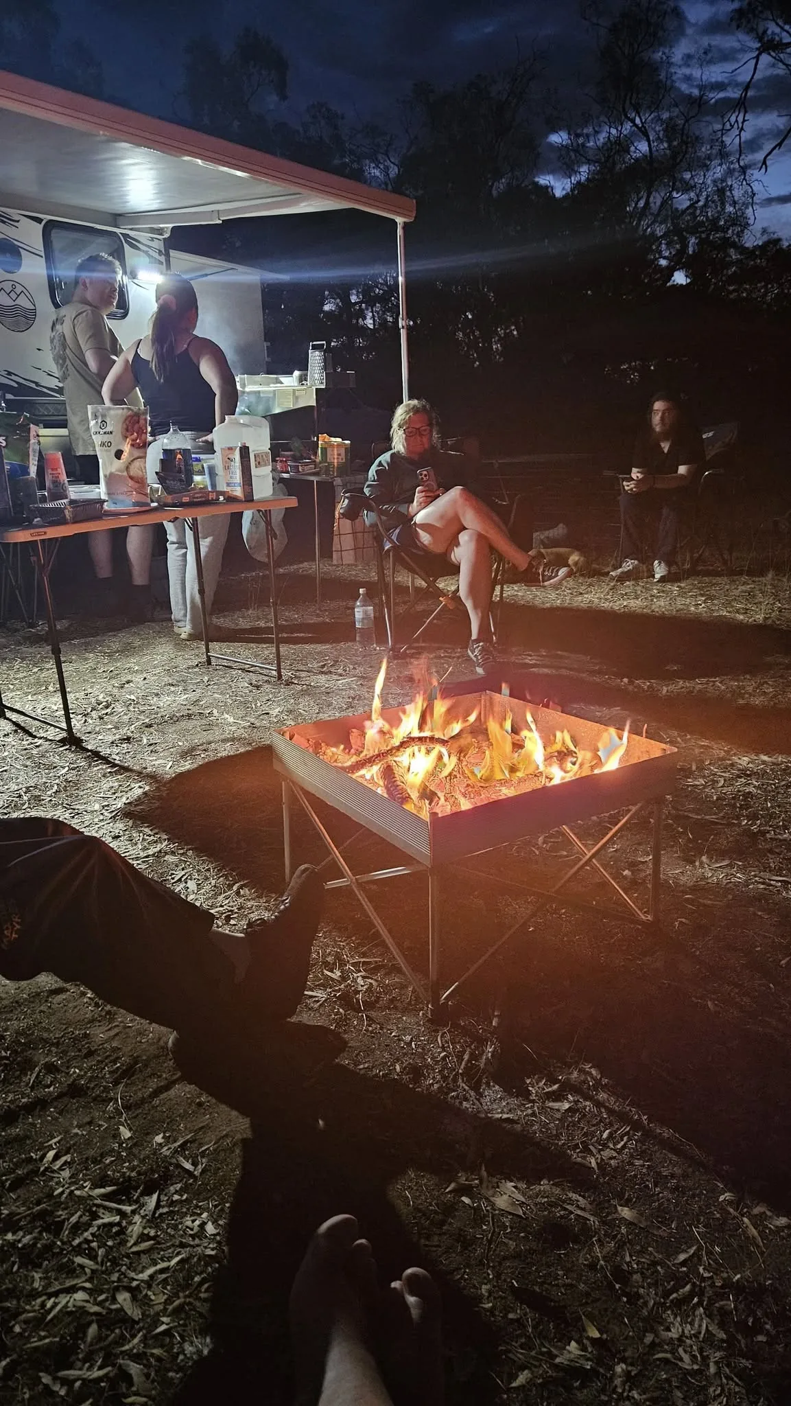 Campfire at night — competitors relaxing under the awning after a day on course